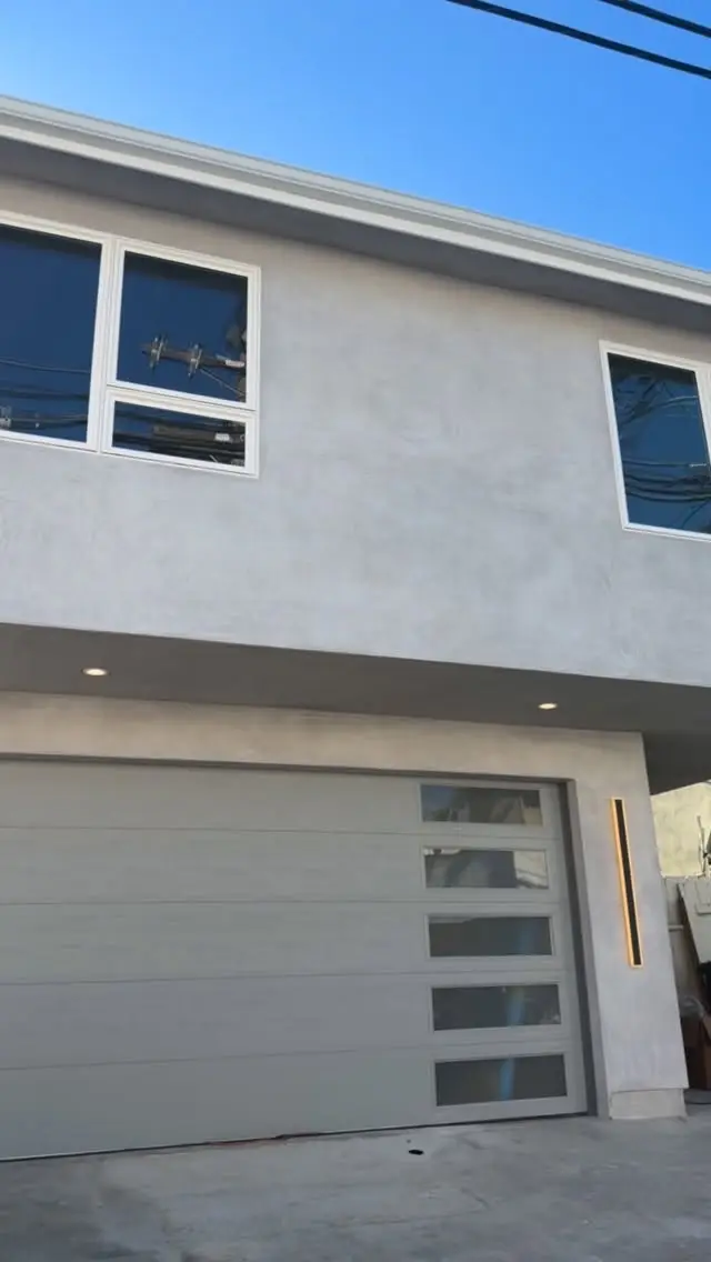 700 sq ft ADU above a garage in San Clemente, CA: smooth stucco and new garage door on an above-garage adu