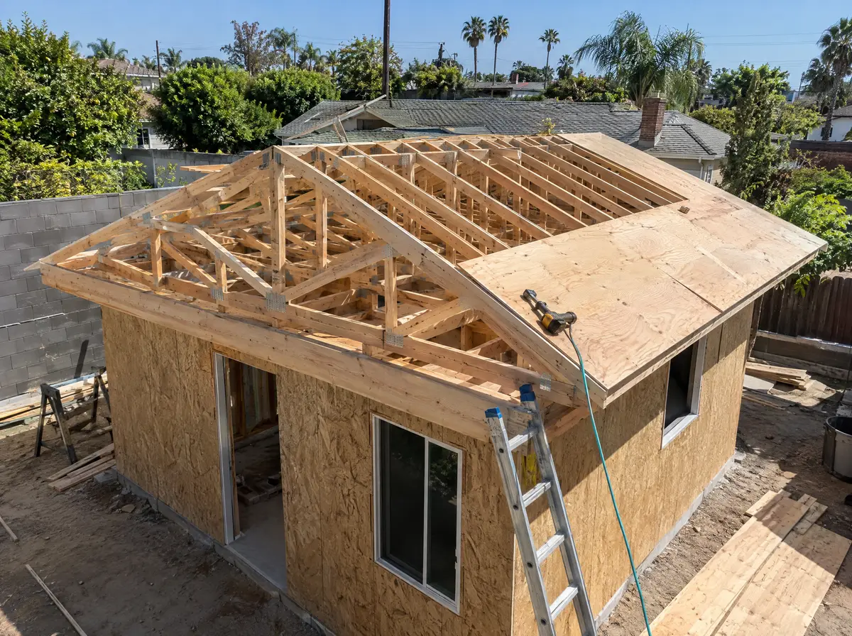 Roof trusses and plywood sheathing going onto a small detached backyard unit