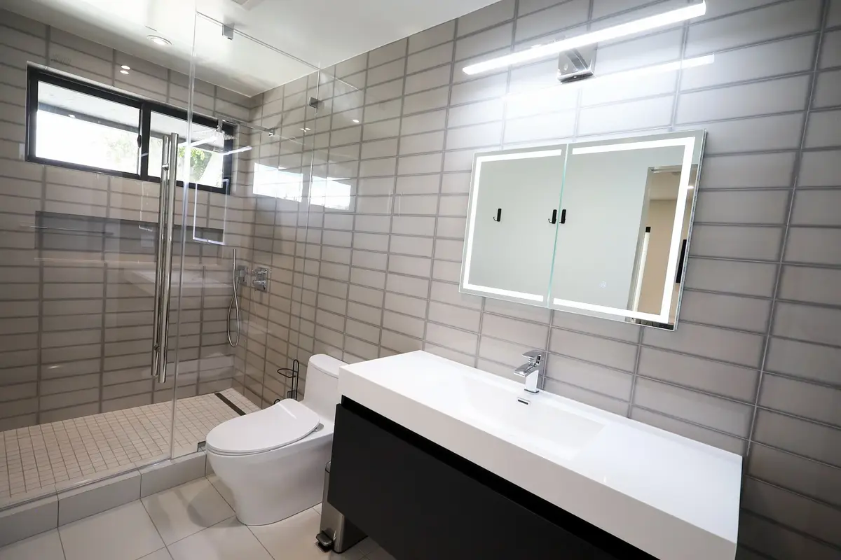 10,308 sq ft modern custom home in Riverside, CA: tiled bathroom with a lit mirror and floating vanity