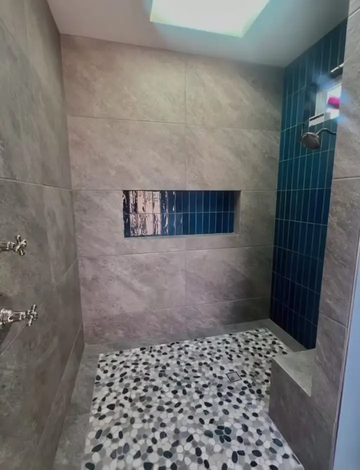 Outdoor shower with large-format tile and a navy accent niche