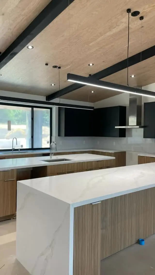 Three-island kitchen in Riverside, CA: contemporary kitchen with multiple islands and black beams