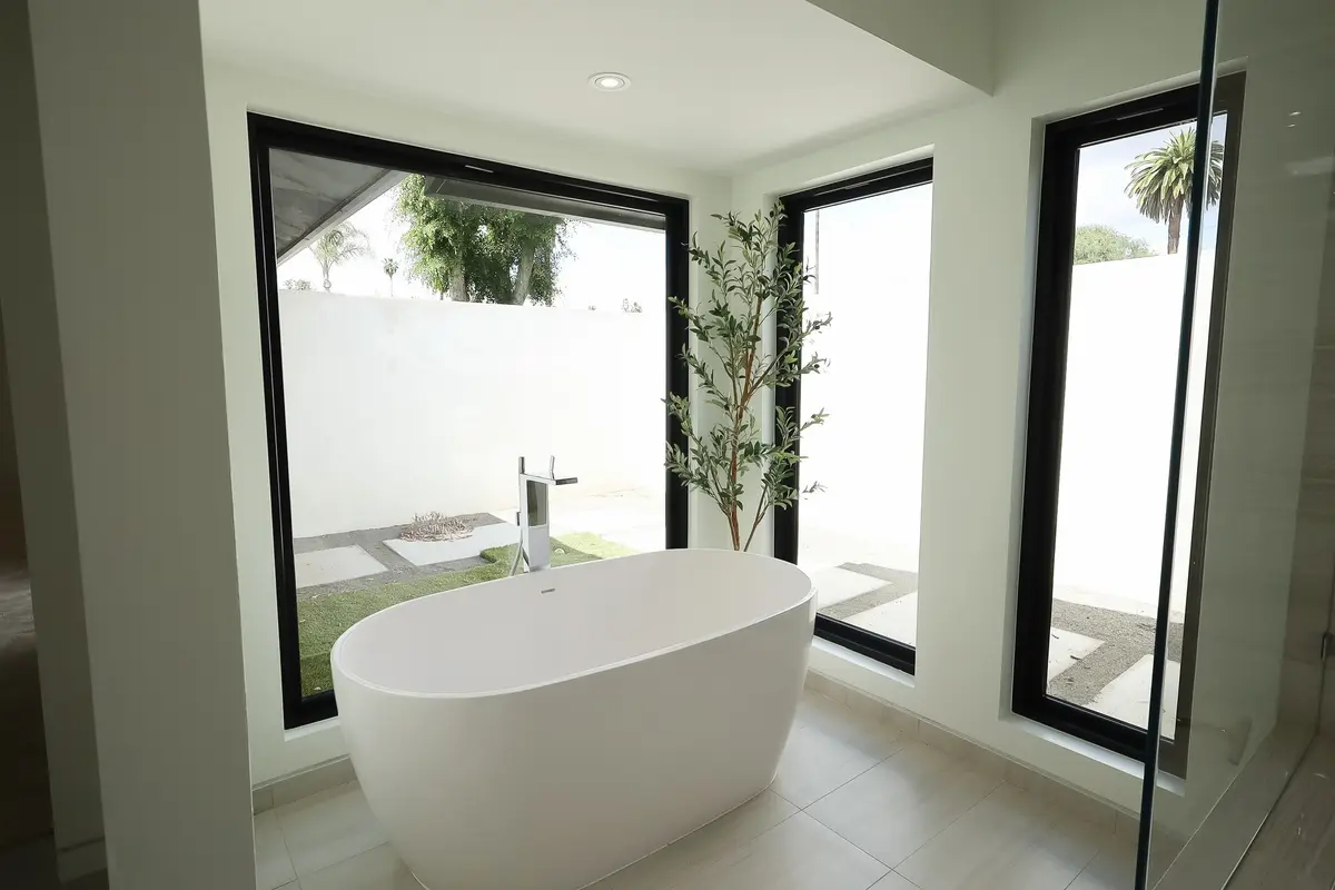 Primary bathroom with a freestanding tub and black-framed windows