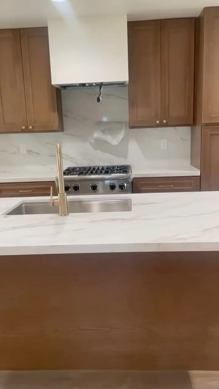 Custom ADU with a pocket corner door in Rancho Cucamonga, CA: quartz countertop and backsplash detail with a gold faucet