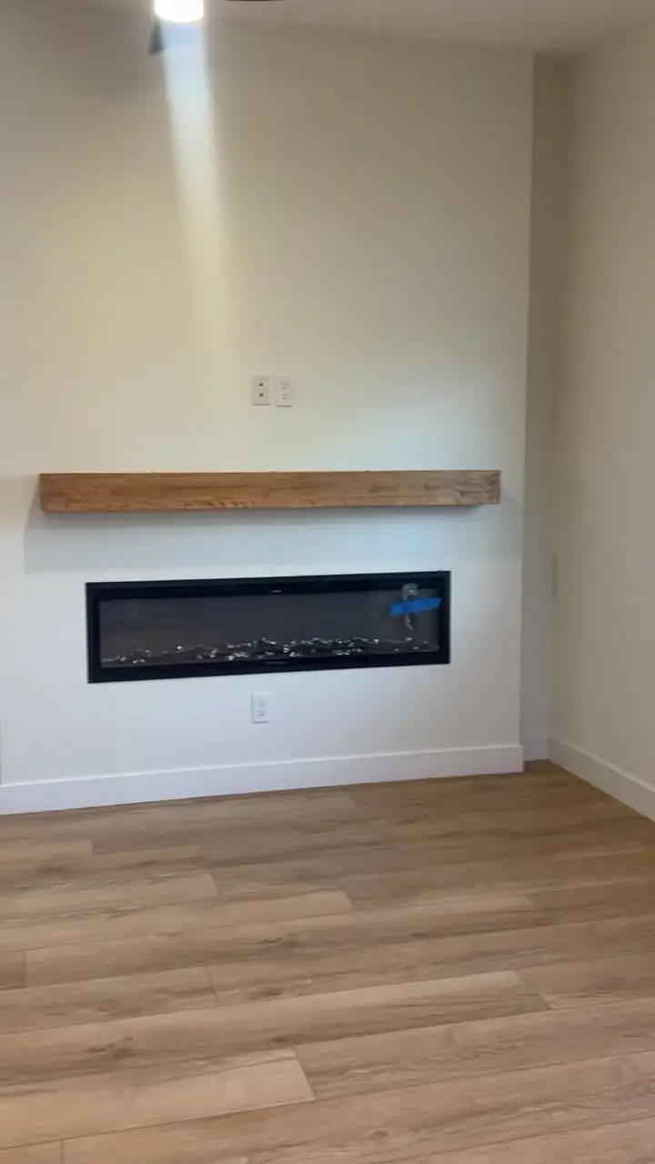 ADU living room with a linear fireplace under a wood mantel